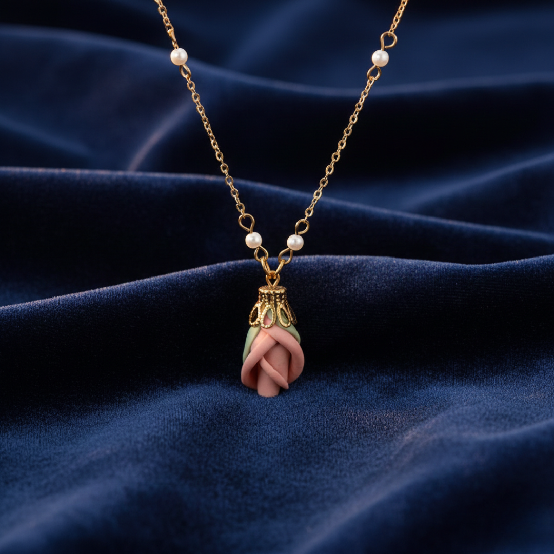 Necklace with a pink flower pendant and small faux pearls on a blue fabric background