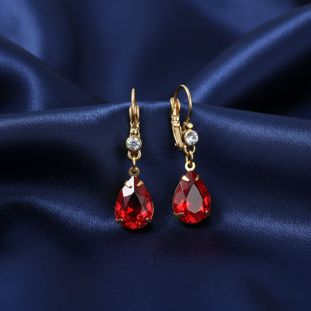 Siam Red Pear Shape Crystal Drop Earrings on blue fabric