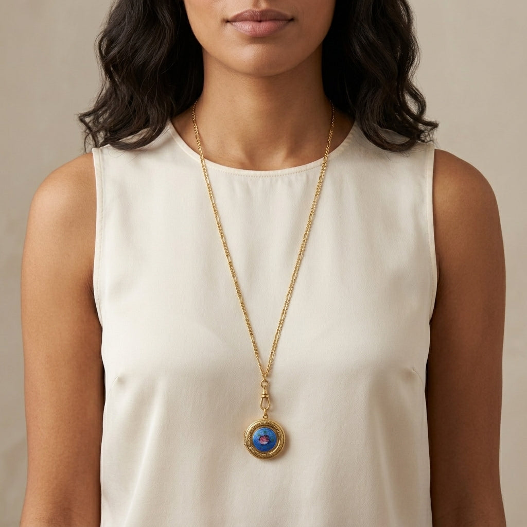 Woman wearing a long necklace with a locket pendant against a neutral background