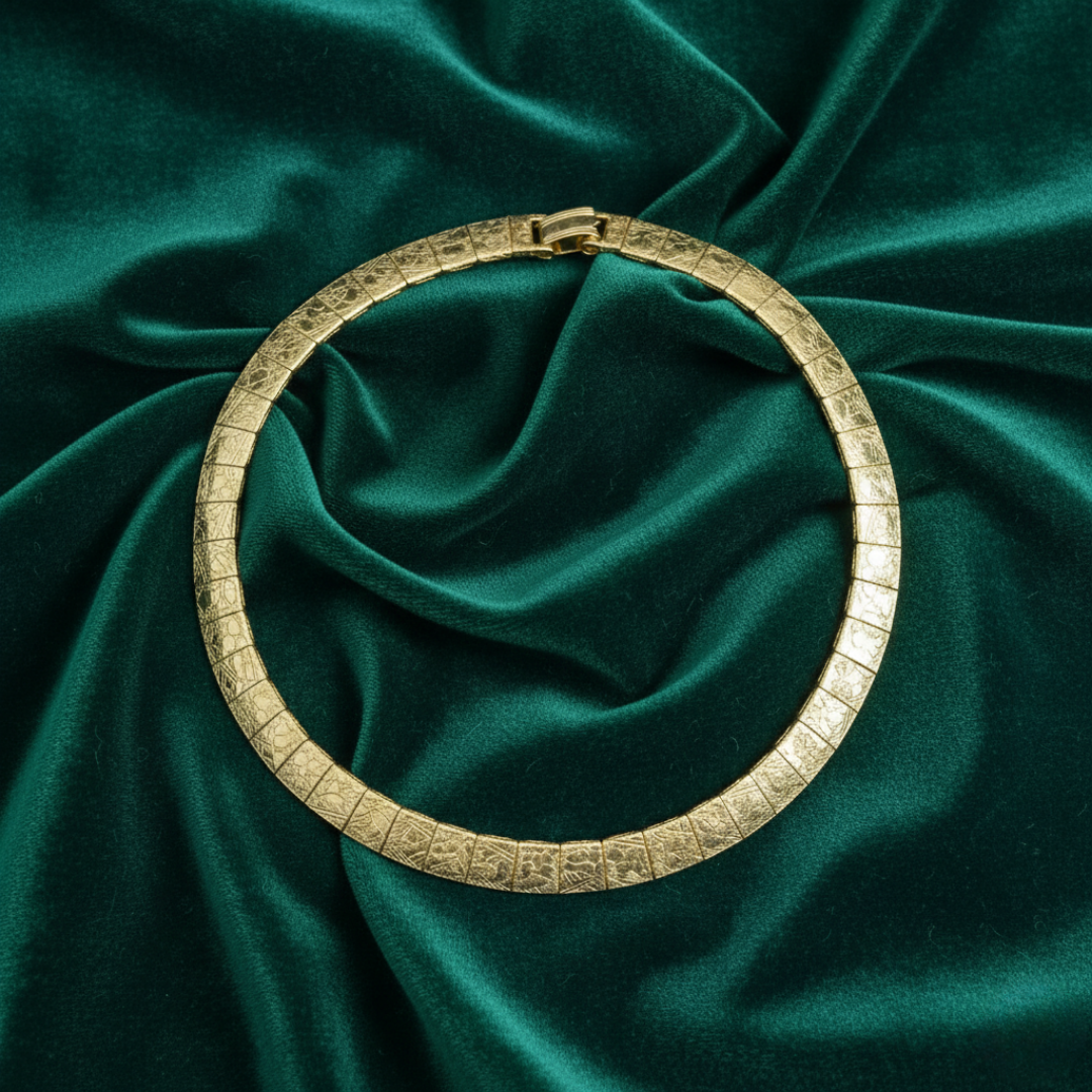 Gold bracelet on a green satin fabric background