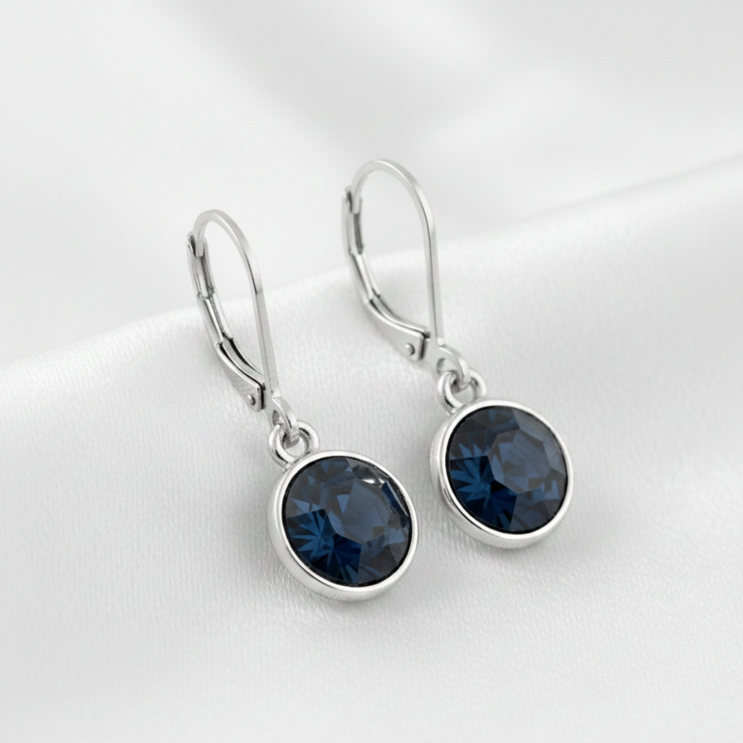 Silver earrings with blue gemstones on a white background