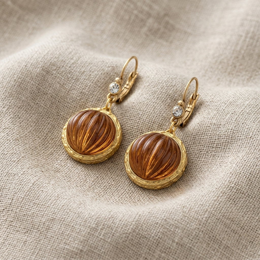 Round Topaz Ribbed Glass Crystal Drop Earrings on a textured beige linen fabric background.