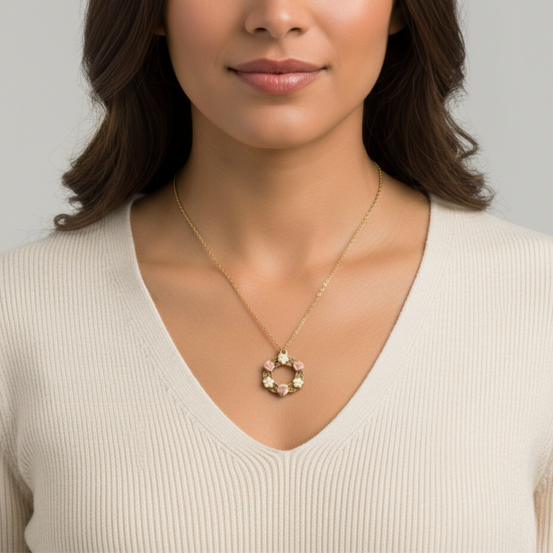Woman wearing a gold necklace with a pink floral pendant against a neutral background