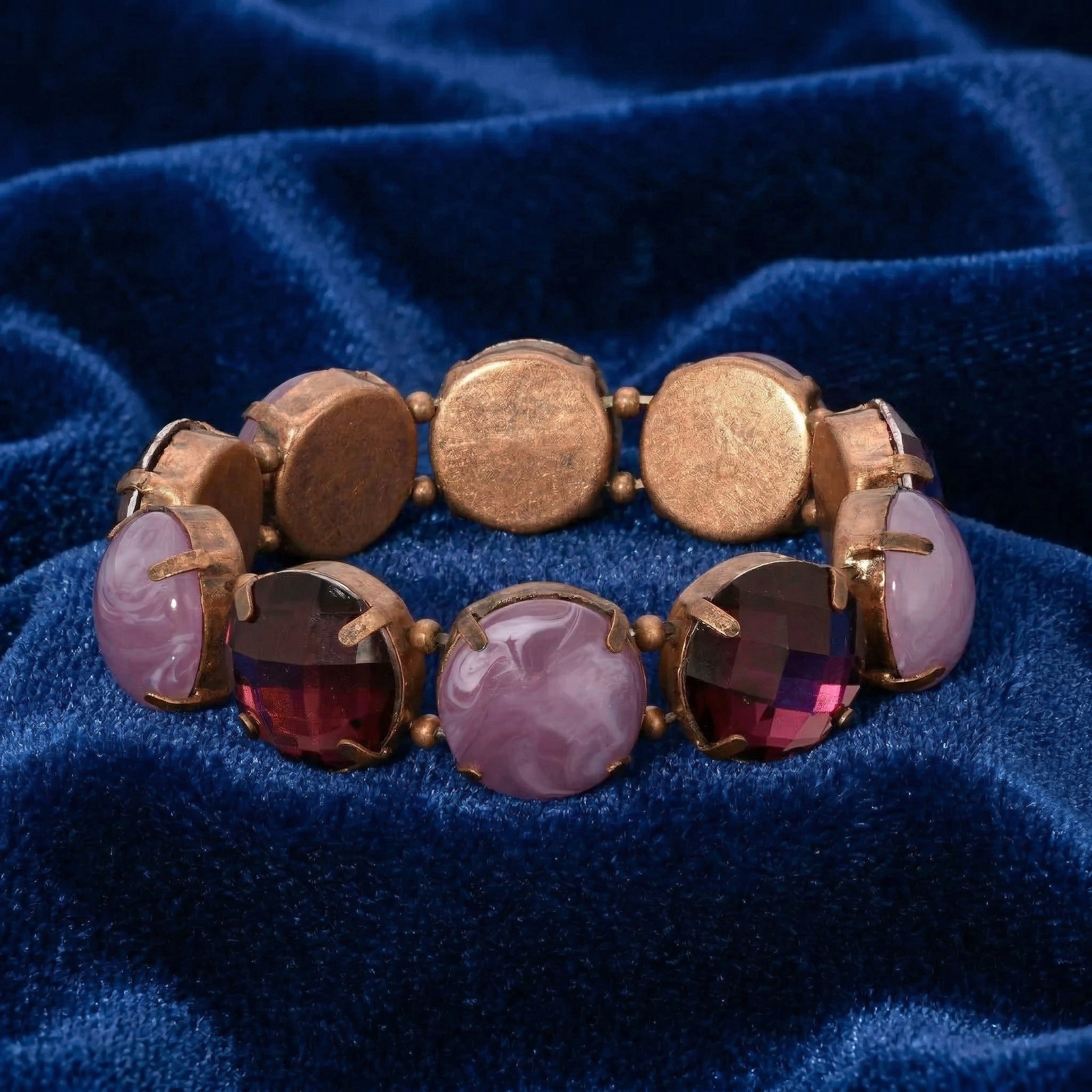 Bracelet with purple crystal beads and gemstones on a blue fabric background