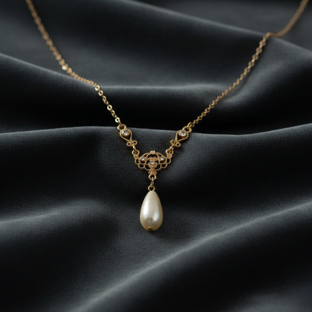 Gold necklace with a pearl pendant on a dark fabric background