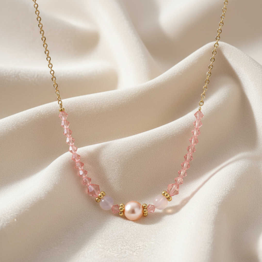 Necklace with pink beads and a pearl on a beige fabric background