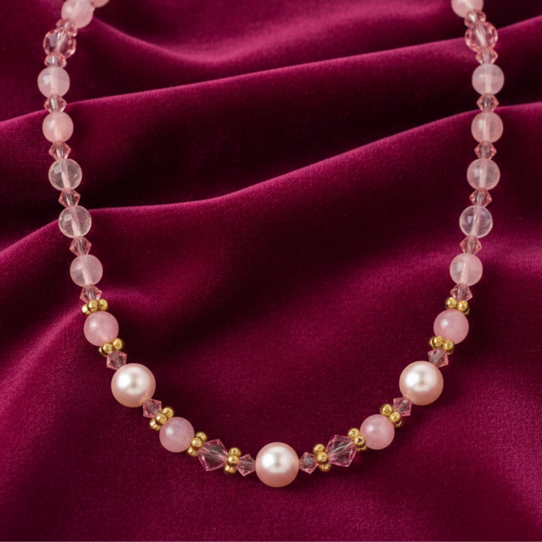 Light rose crystal beads is softly paired with blush faux pearls on a dark pink fabric.