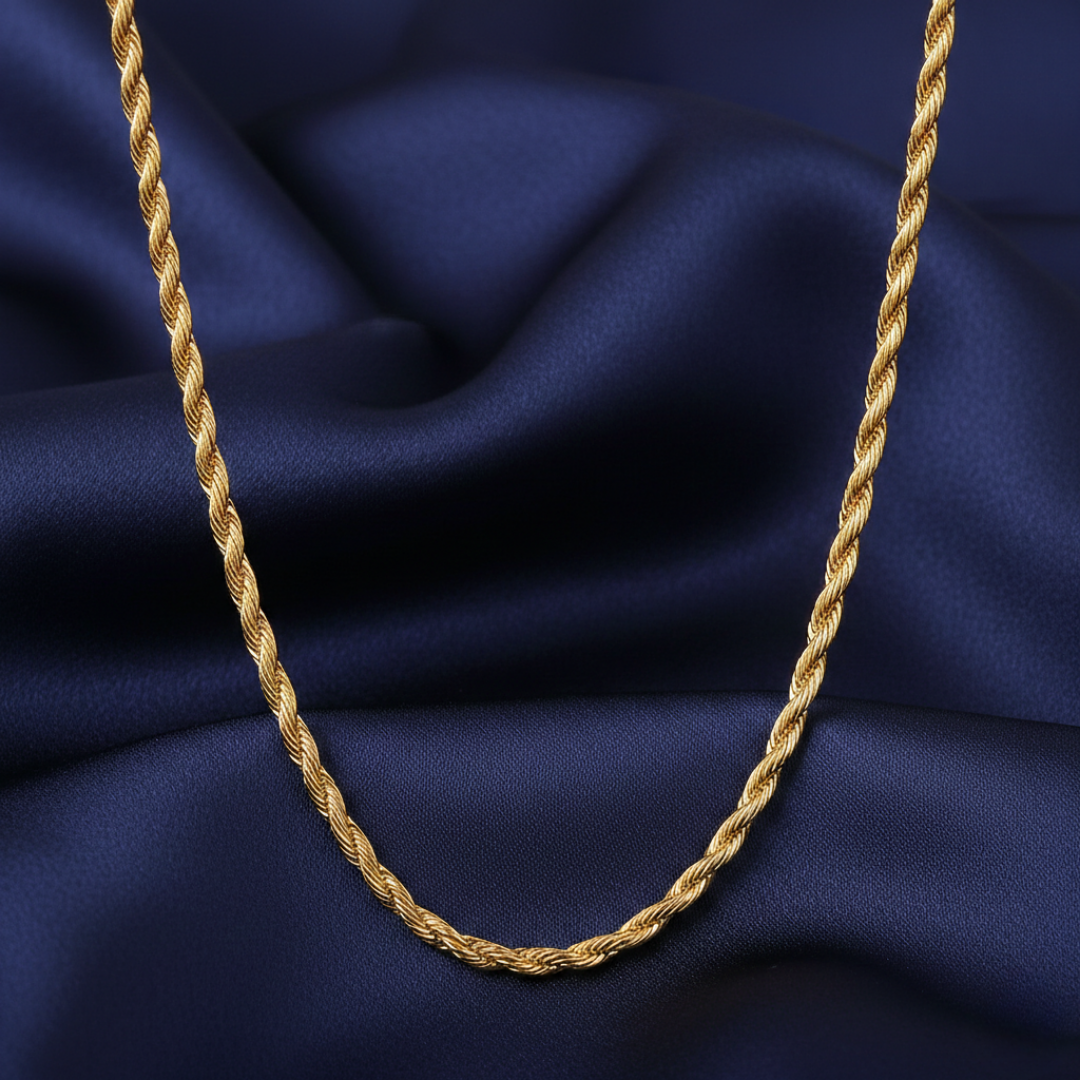 Gold rope chain necklace on a blue fabric background