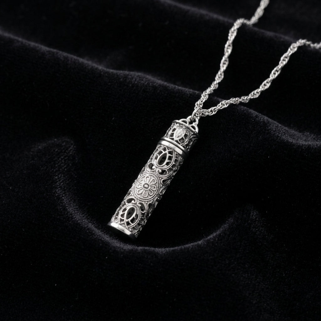 Silver necklace with intricate vial pendant on a black background