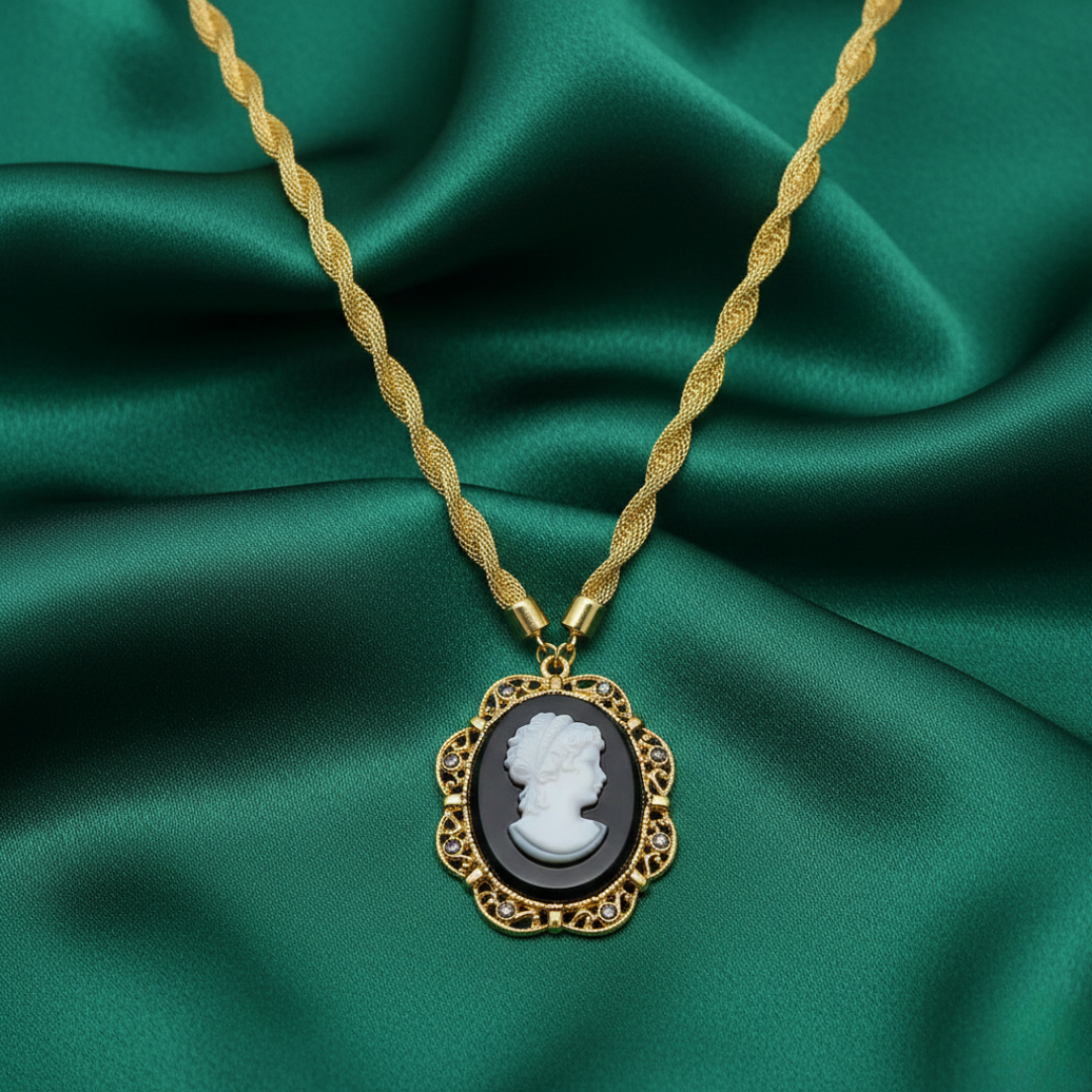 Gold necklace with a cameo pendant on green fabric