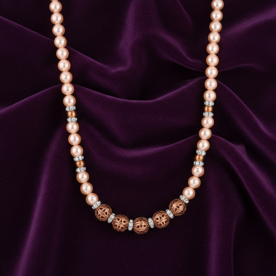 Pearl necklace with bronze and silver accents on a purple fabric background