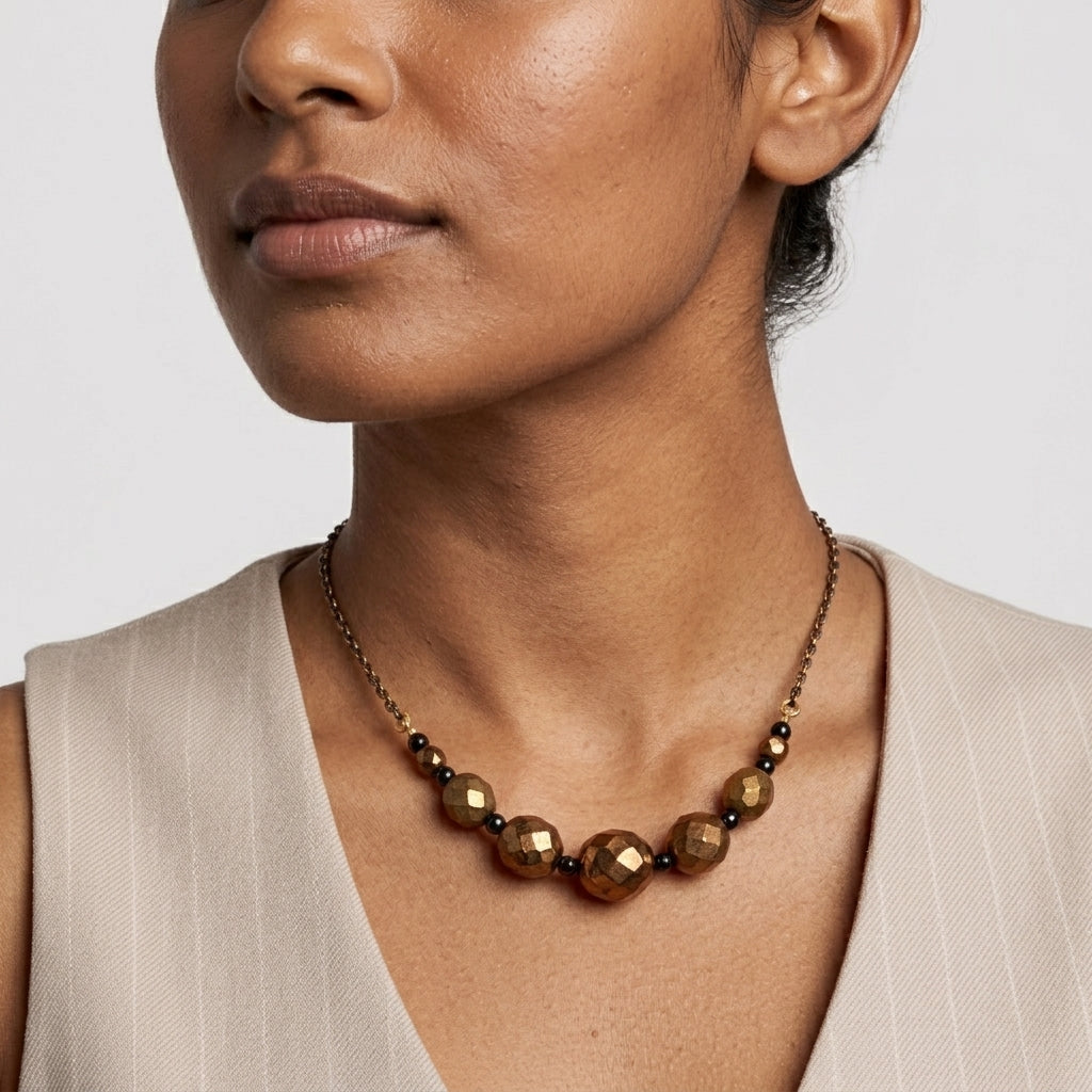 Woman wearing a beaded brown necklace with a neutral background