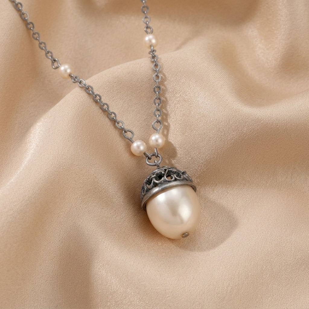 Whispering Faux Pearl Filigree Pendant Necklace resting on cream colored satin fabric
