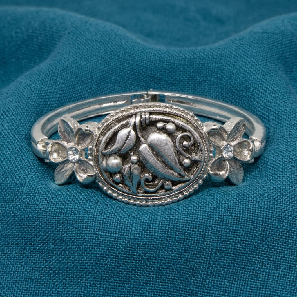 Silver tone Spring Garden Bloom Bracelet resting on blue linen