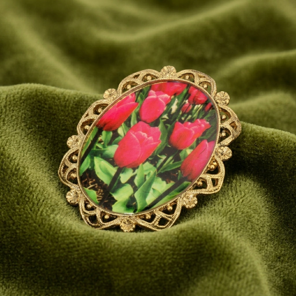 Decorative brooch with floral tulip design on a green fabric background