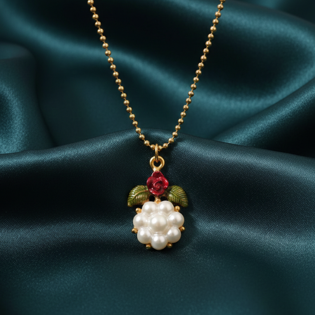 Necklace with a pearl and floral pendant on a dark green fabric background