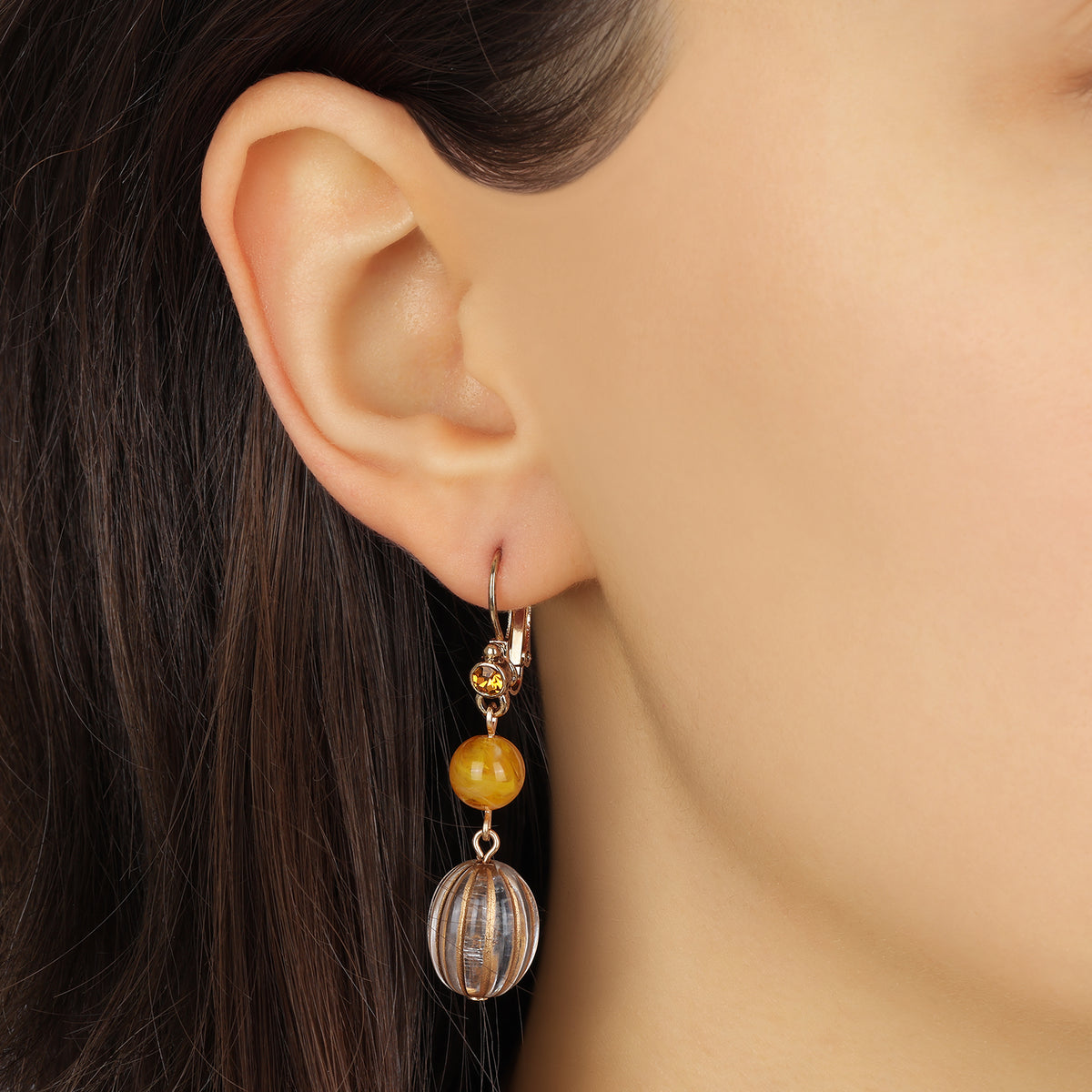 A close-up of a person's ear wearing a Topaz Bead & Crystal Drop Dangle Earrings