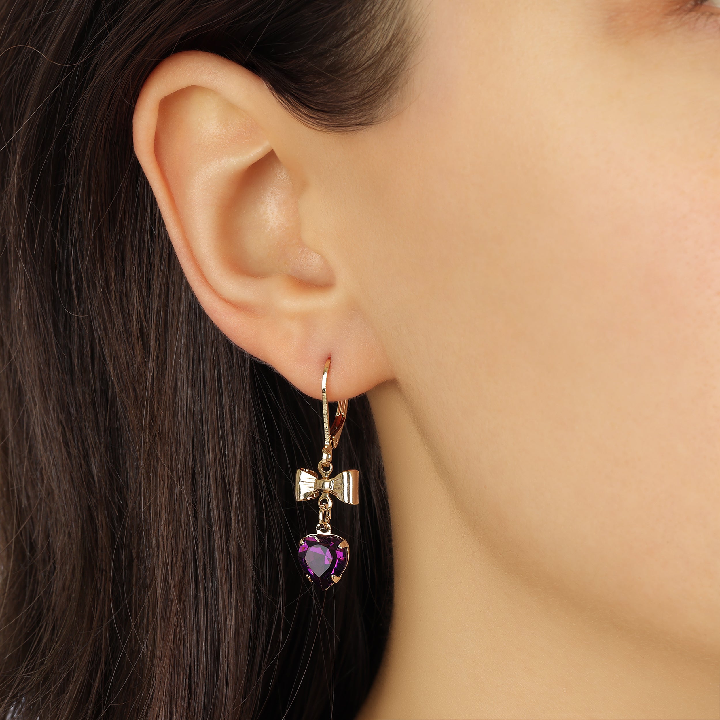 Close up of a woman wearing Golden Bow Amethyst Crystal Heart Drop & Dangle Earrings