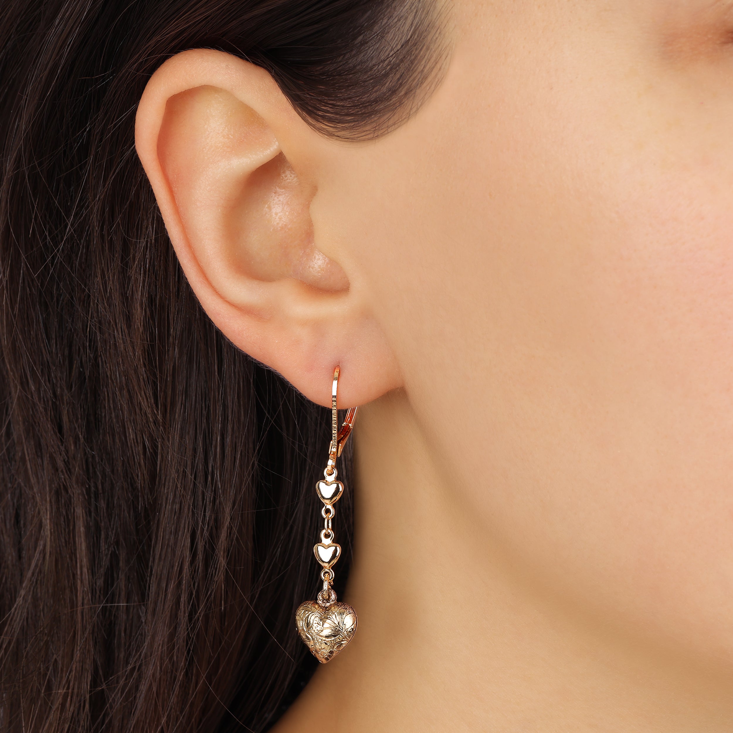 Close up of a woman wearing Classic Golden Heart Drop & Dangle Earrings