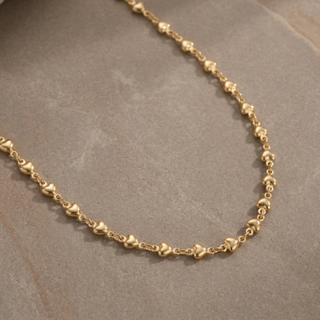Classic Golden Heart Link Chain Necklace 16" displayed on a textured gray surface.