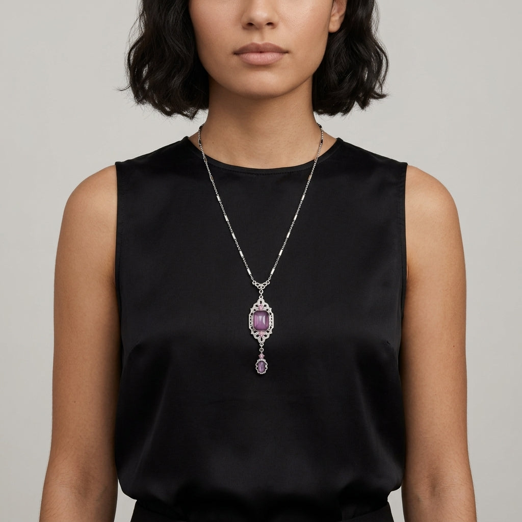 Woman in a black sleeveless top wearing a purple stone drop pendant necklace