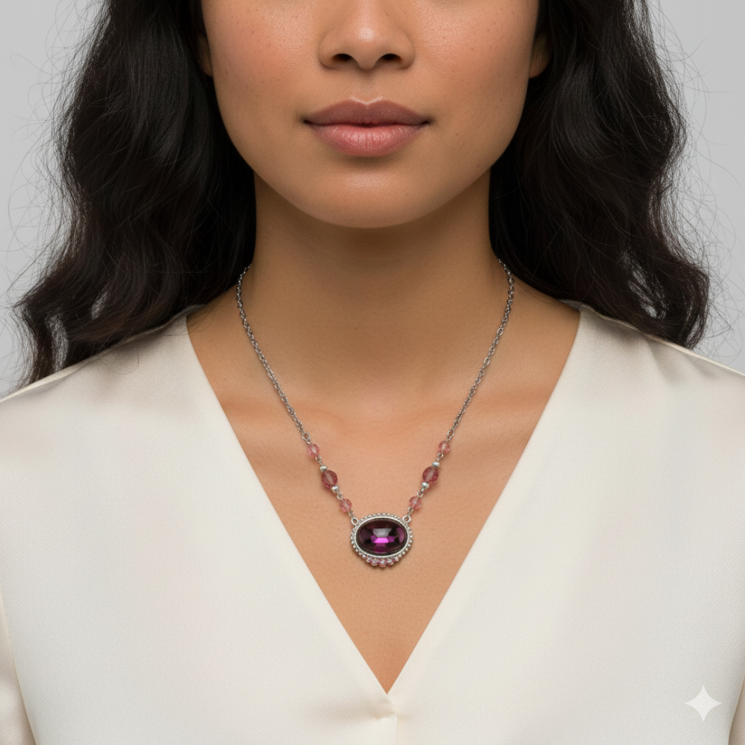 Woman wearing a necklace with a purple gemstone pendant on a plain background