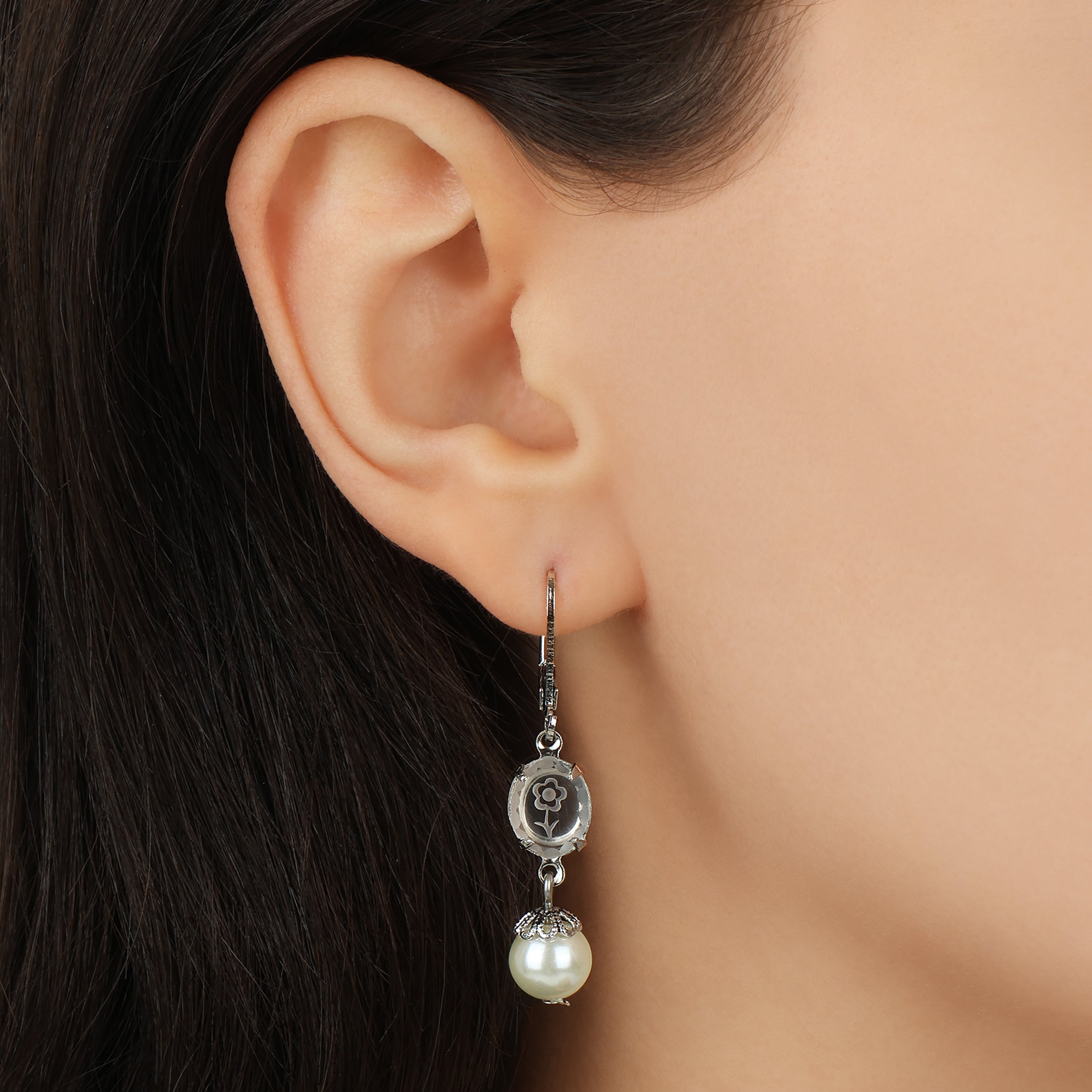 Close up of a woman wearing Silver Flower Engraved Crystal & Round Faux Pearl Drop Earrings