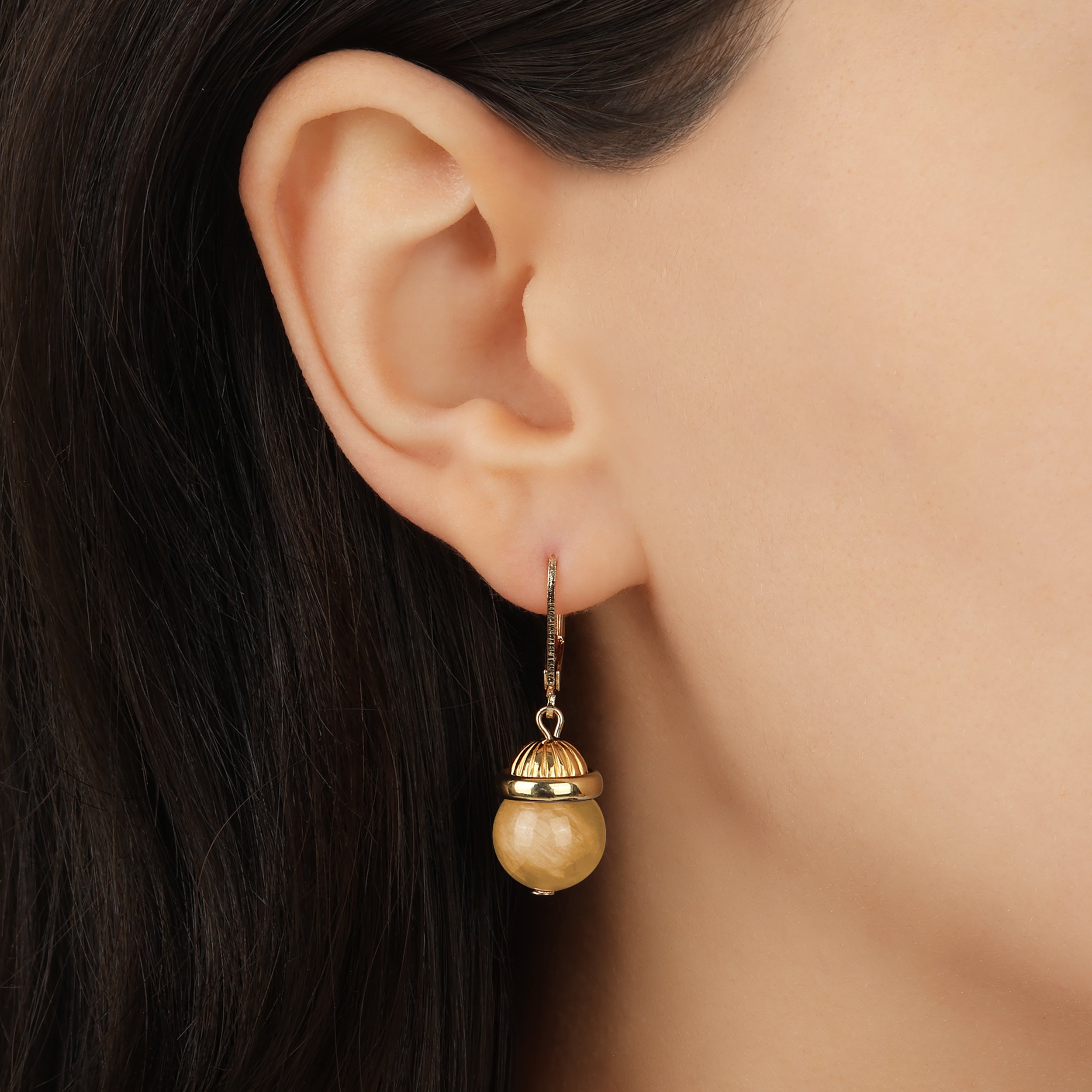 Close up of a woman wearing Petite Round Yellow Quartz Gemstone Drop Earrings