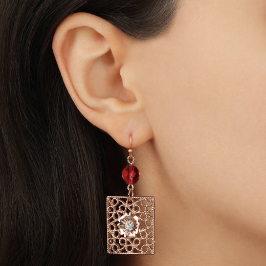 Close up of a model wearing Rose Gold Square Filigree Red Fire Polished Glass Crystal Drop & Dangle Earrings