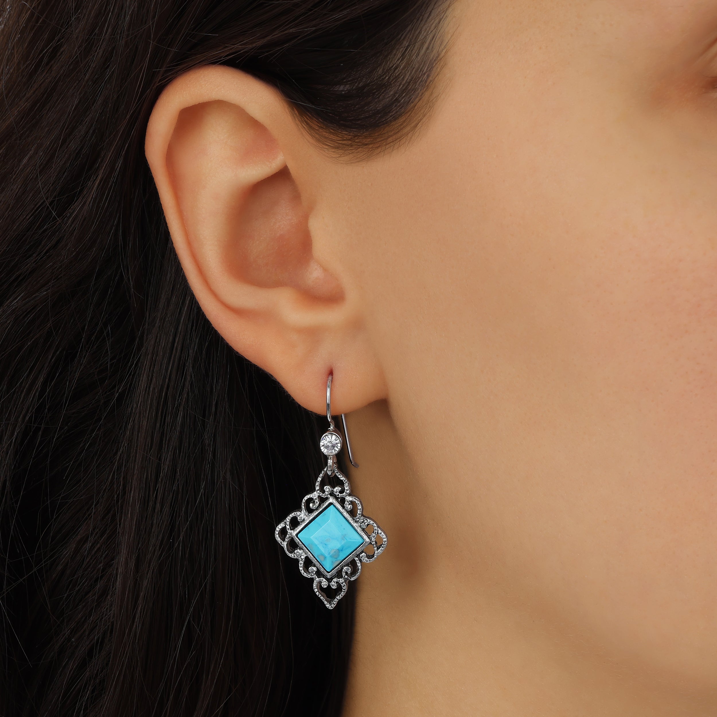 Close up of a woman wearing Silver Filigree & Turquoise Diamond Shaped Stone Drop Earrings