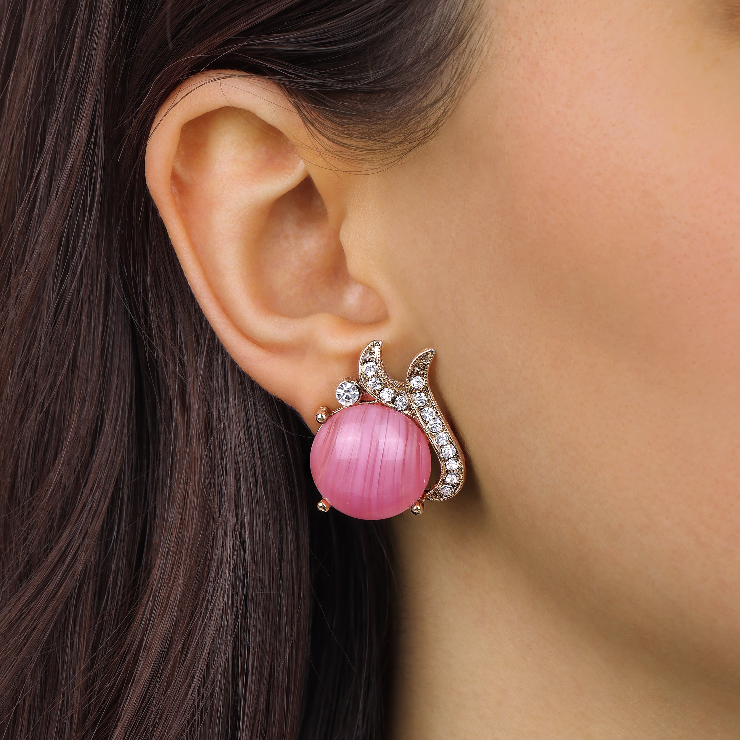A close-up of a woman's ear wearing a Round Pink Rose Quartz Cabochon Stone & Crystal Post Stud Earrings