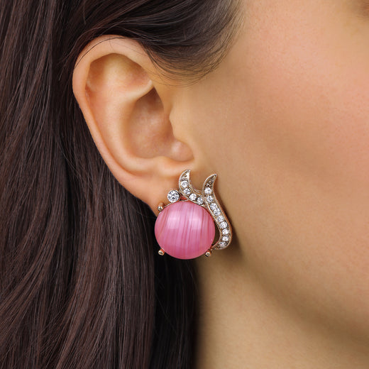 A close-up of a woman's ear wearing a Round Pink Rose Quartz Cabochon Stone & Crystal Post Stud Earrings