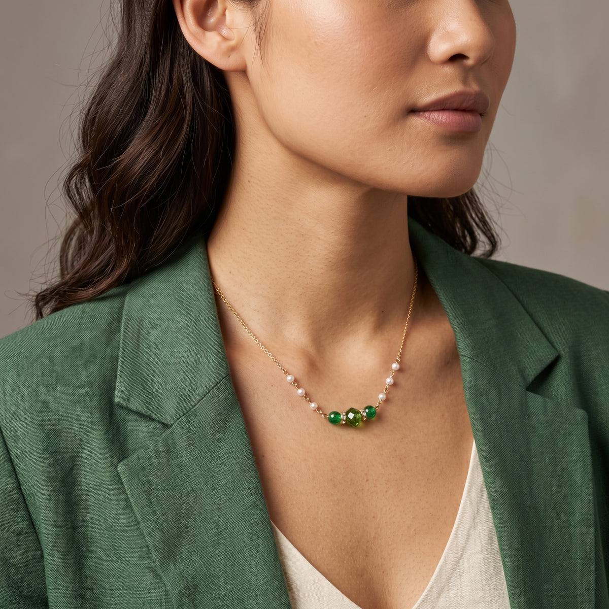 A woman in a green blazer wearing an Emerald Green Glass Beads & Faux Pearl Chain Necklace 15" + 3" Extension
