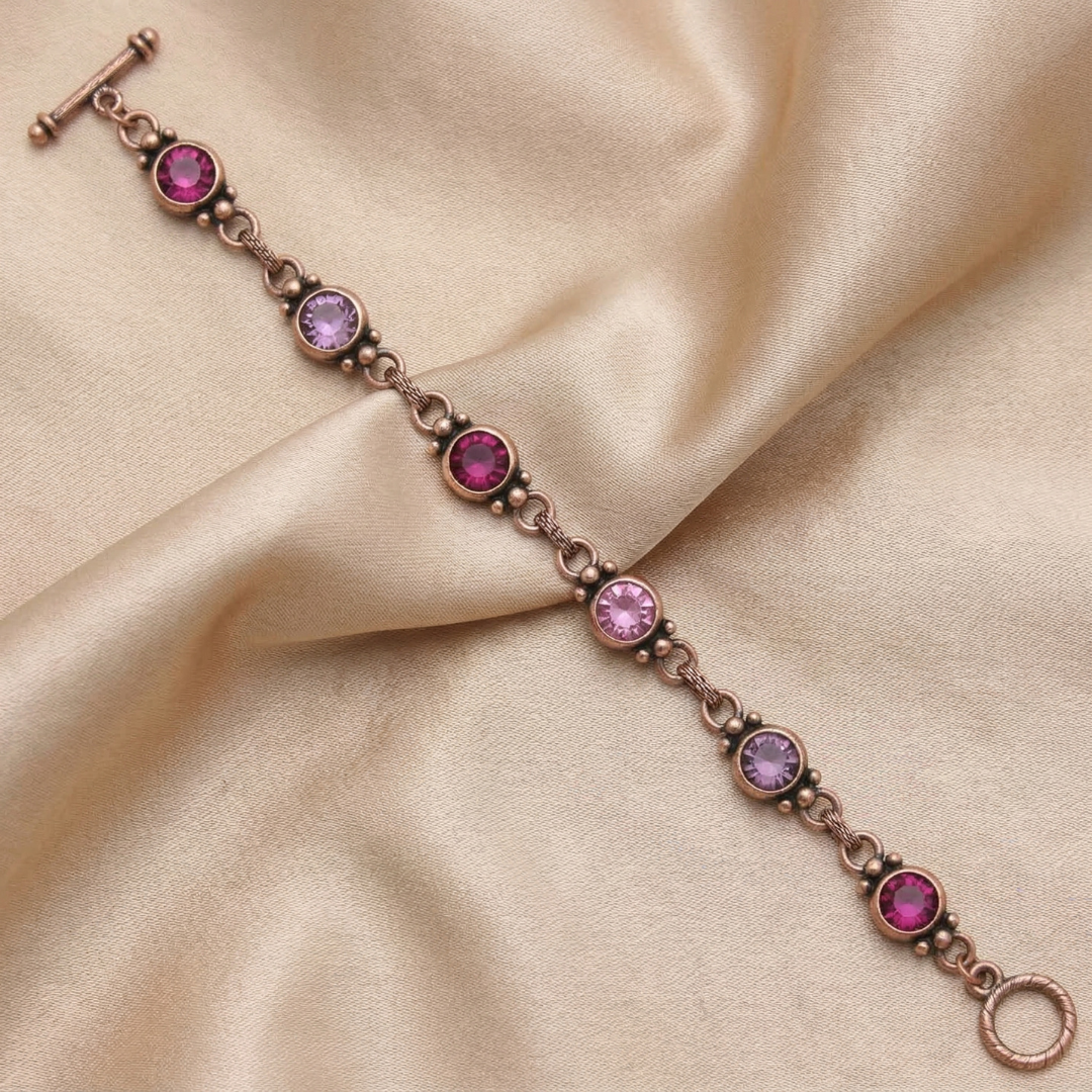 Bracelet with pink gemstones on a beige satin background