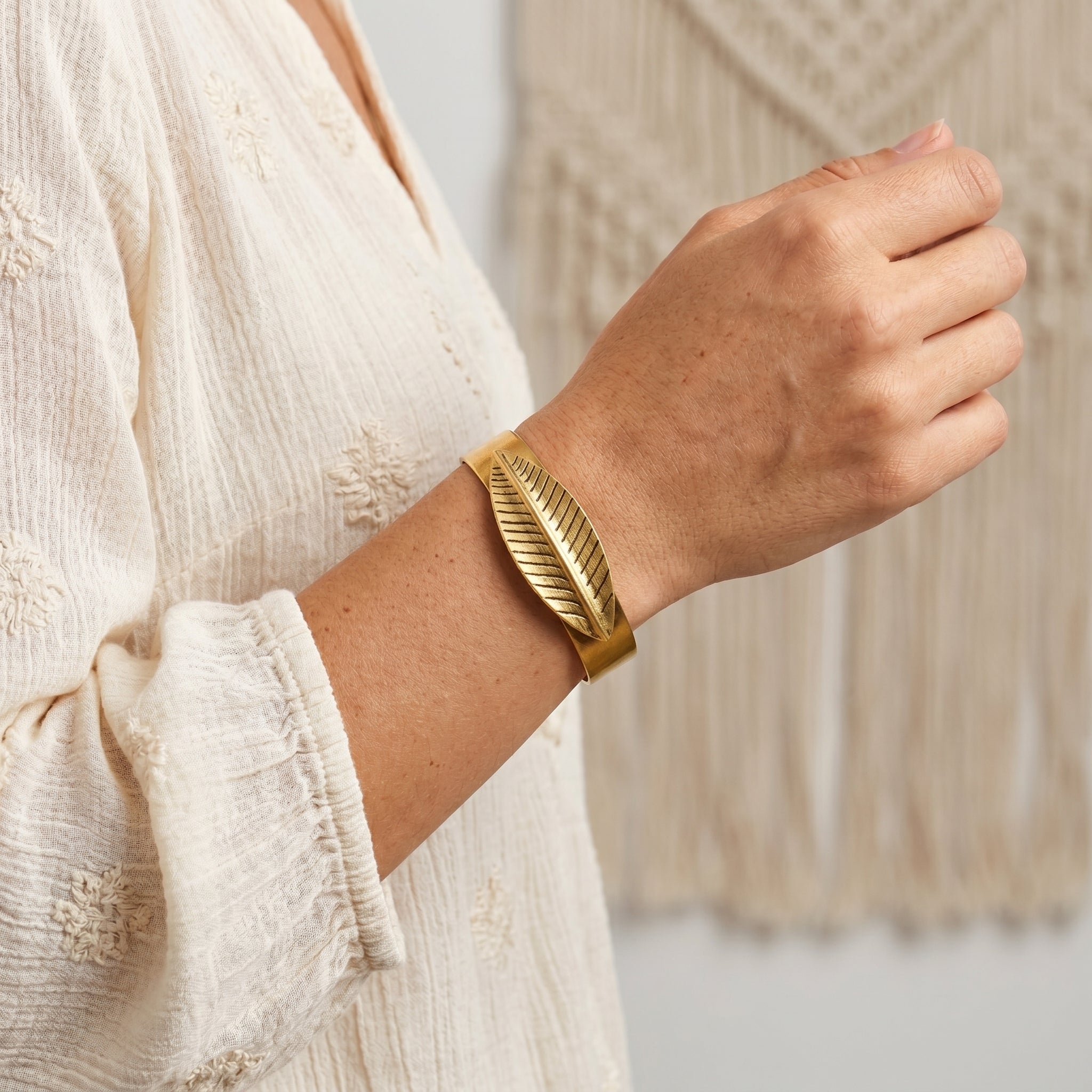 Woman in a BoHo outfits wearing a gold tone Feather Bangle Bracelet