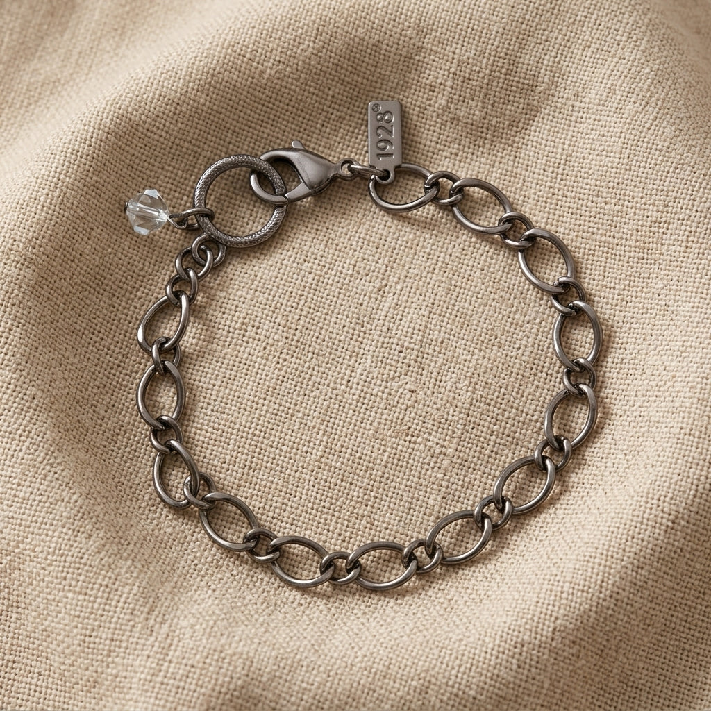 Pewter chain bracelet with a clear crystal stone bead on beige linen fabric