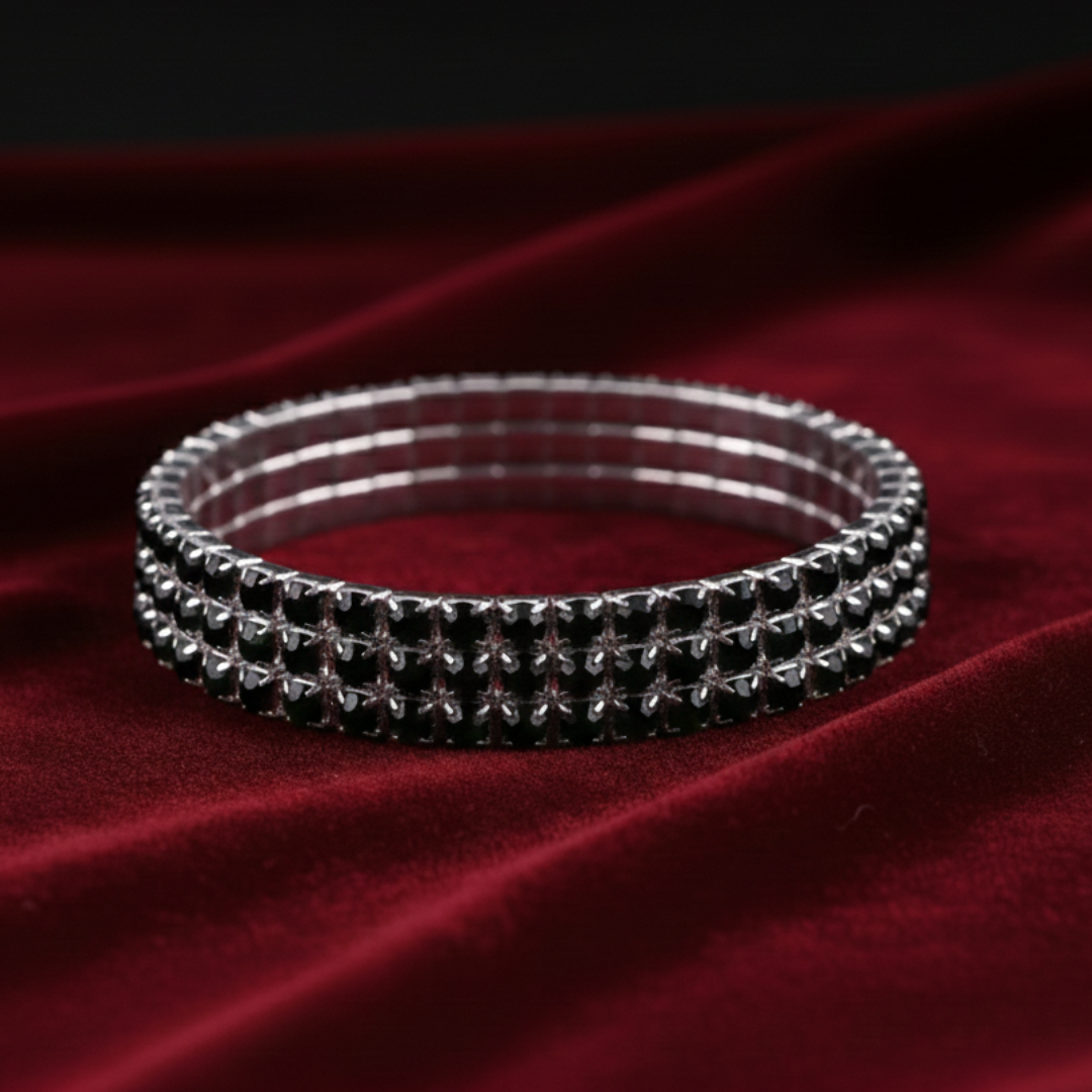 Silver bangles with black stones on a red fabric background