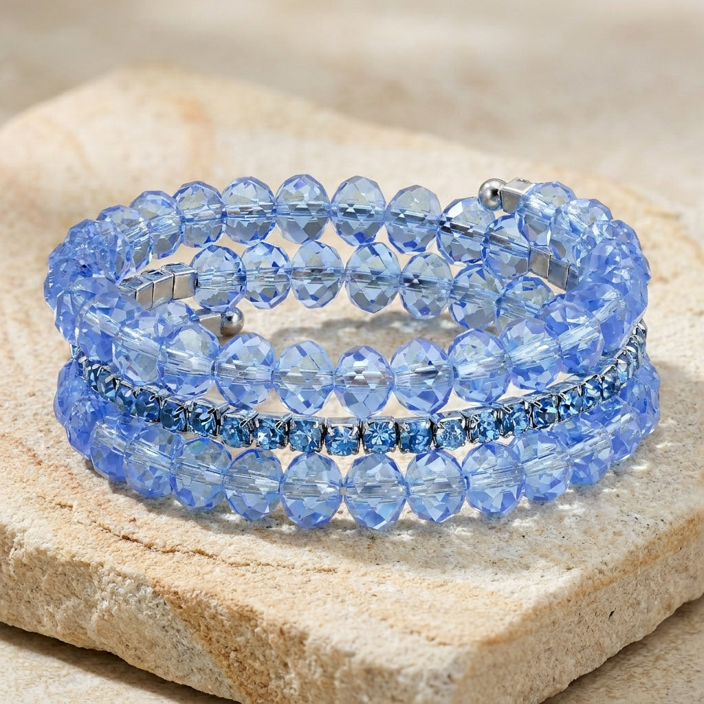 Blue Lux-Cut Beaded Glass Crystal Coil Bracelet on a stone surface