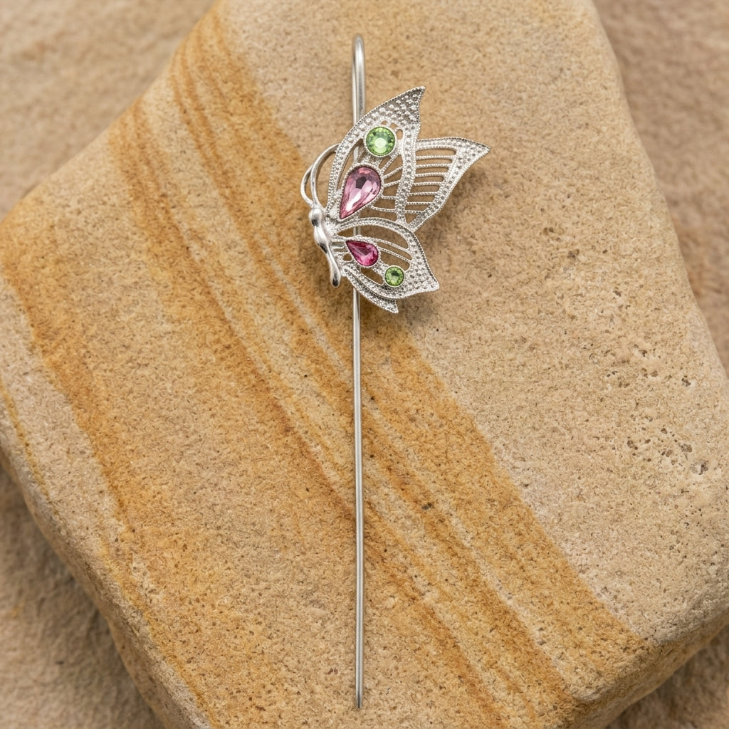 Butterfly bookmark with pink and green crystals on a sandstone surface