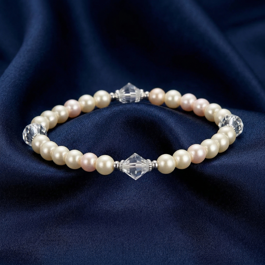 Ivory Faux Pearl And Lantern Crystal Stretch Bracelet on dark blue satin fabric