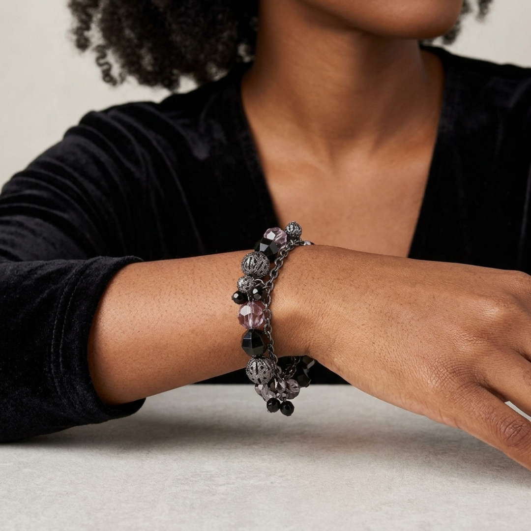 Person wearing a bracelet with intricate designs on a neutral background