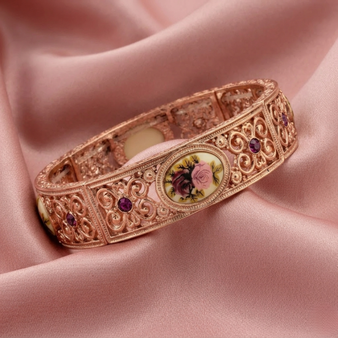Decorative bracelet with floral design and purple crystals on a pink fabric background