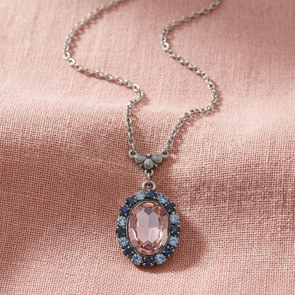 Anastasia Blue Rimmed Pink Oval Pendant Necklace on a pink linen fabric background