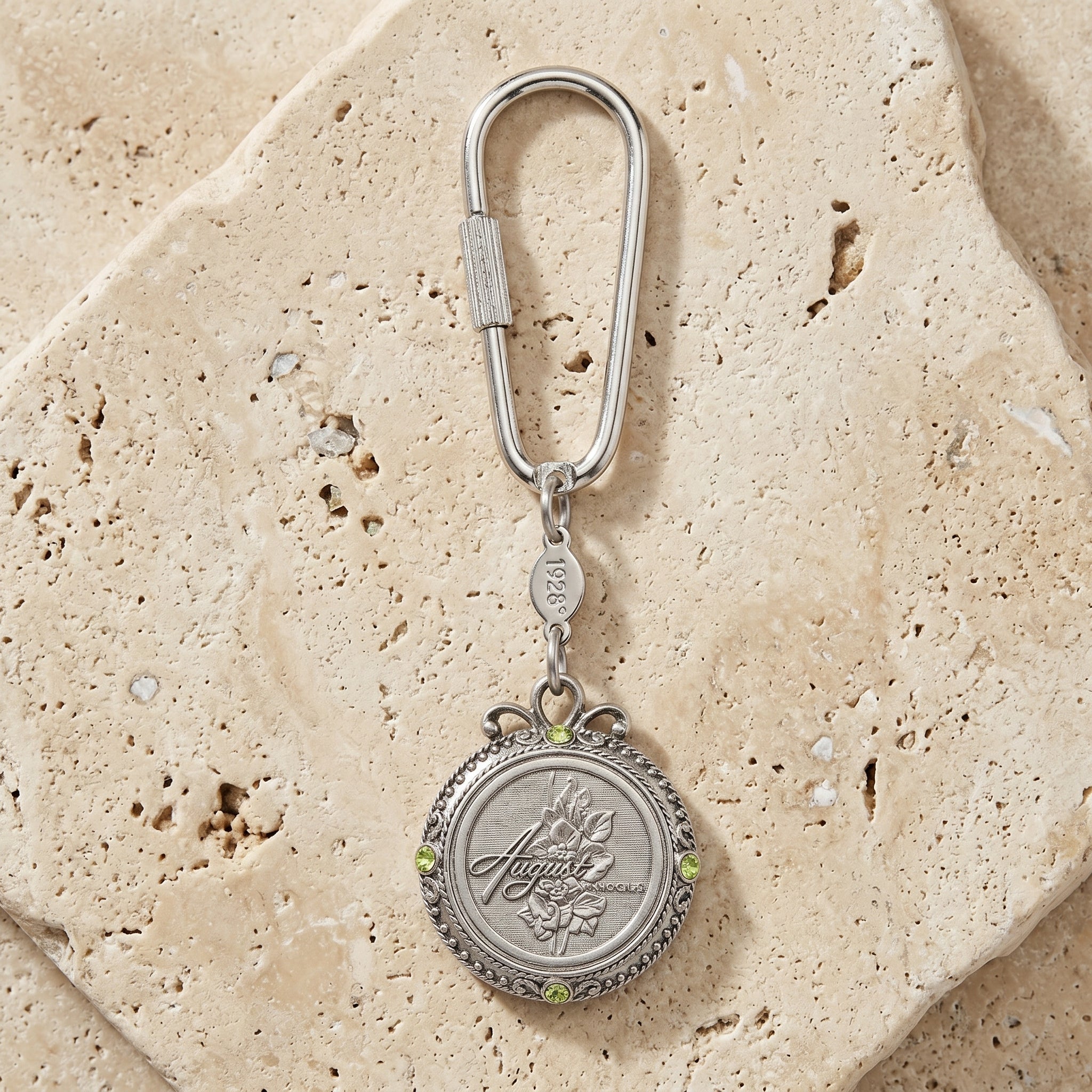 August Crystal Flower of The Month Carabiner Key Chain resting on a stone surface