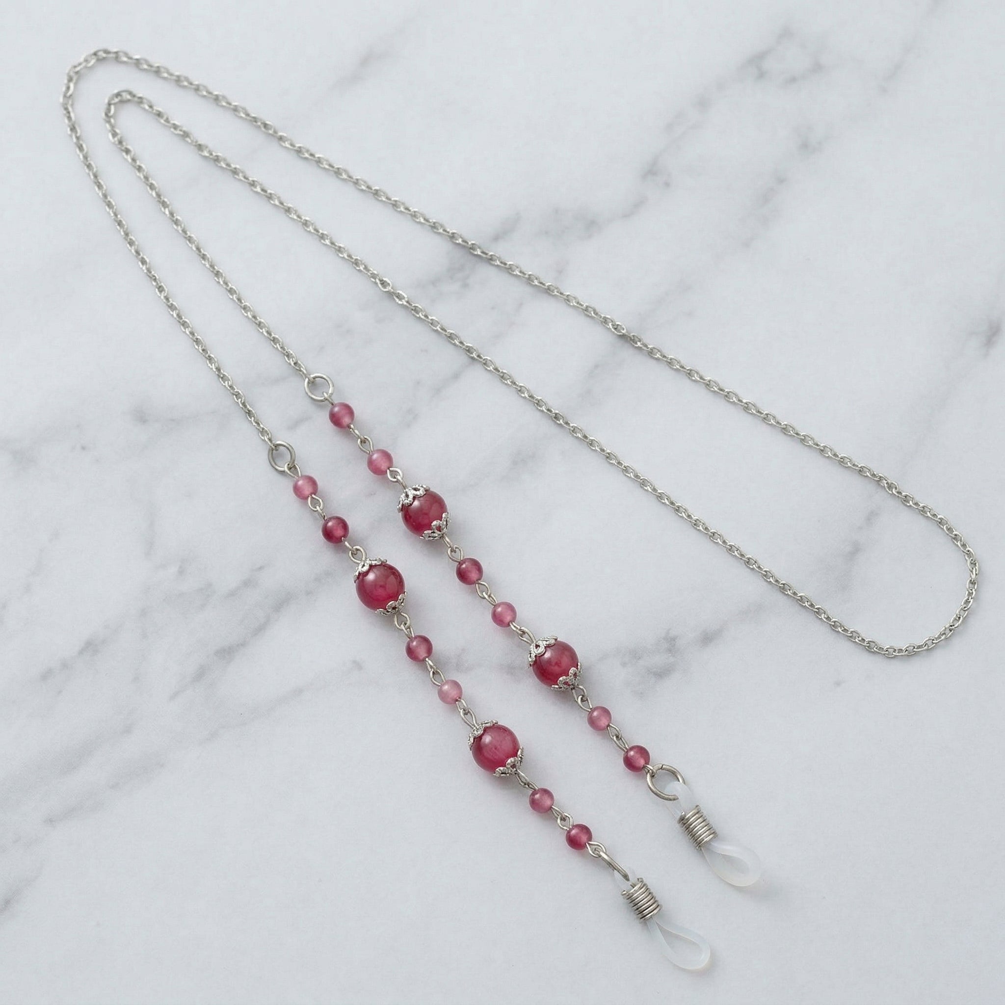 Coral And Pink Bead Eyeglass Holder Chain Necklace on a marble surface