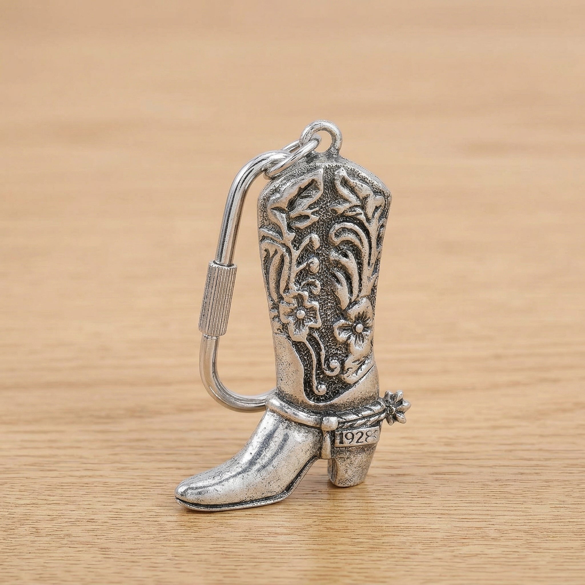 Pewter Cowboy Boot Carabiner Key Chain on a wooden surface