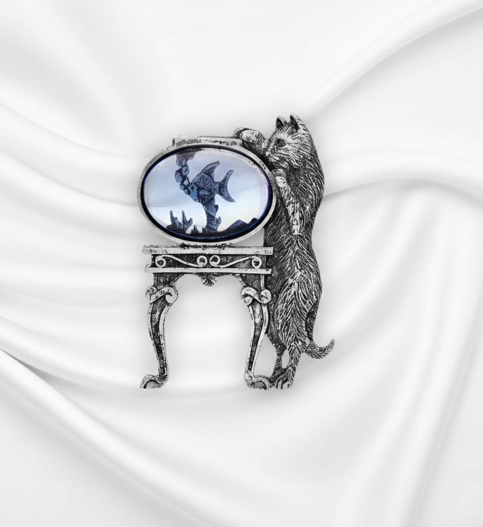 Decorative brooch with a cat design on a white fabric background.