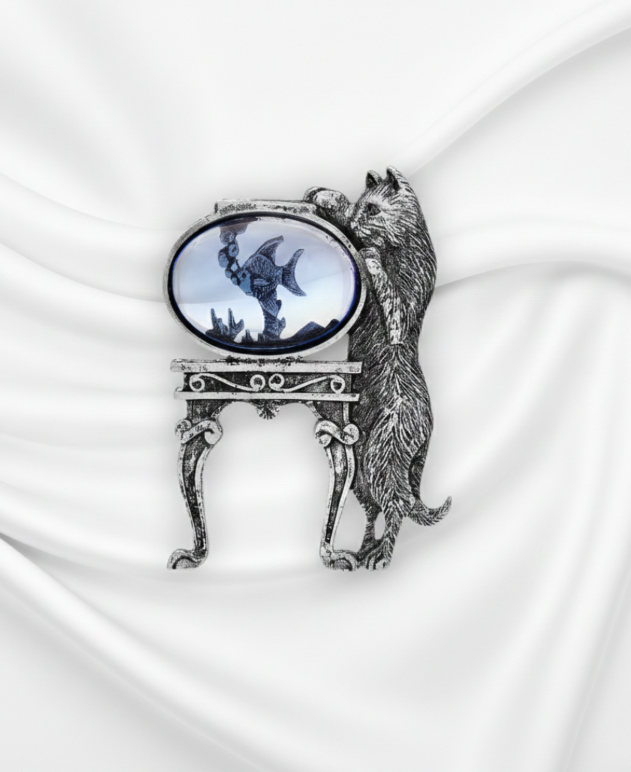 Decorative brooch with a cat design on a white fabric background.