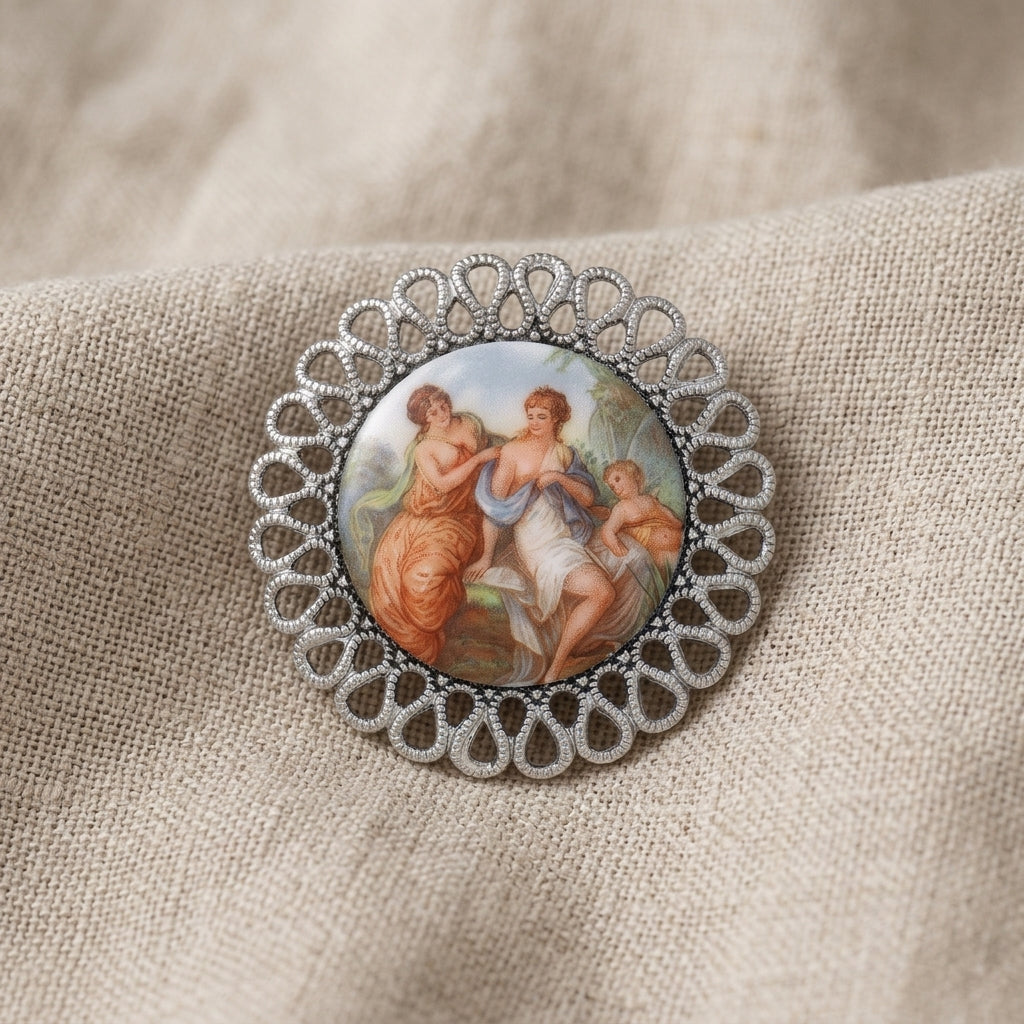 Decorative silver tone brooch with classical design on a textured fabric background