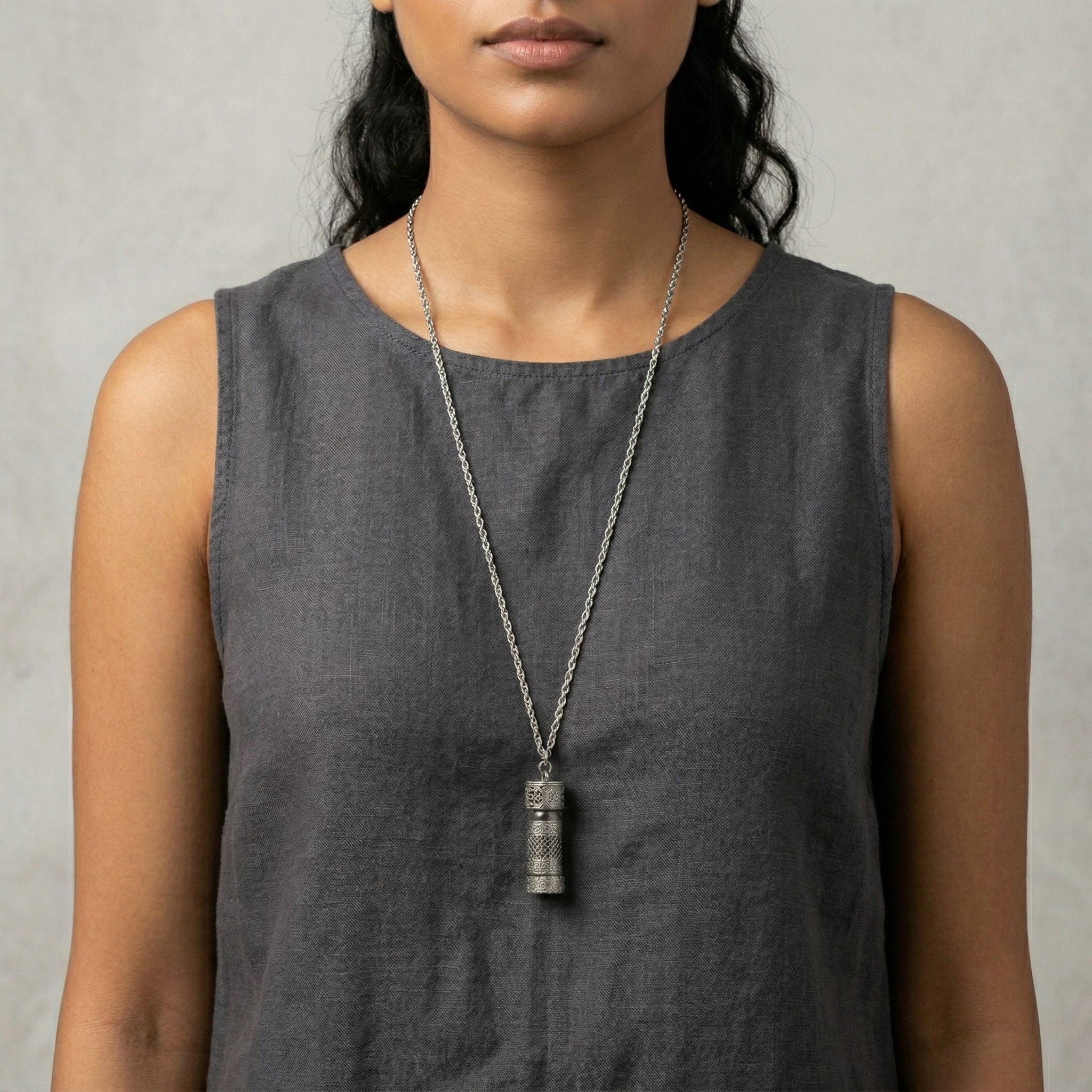Etched Pewter Floral Glass Vial Necklace worn by a woman in a gray sleeveless top